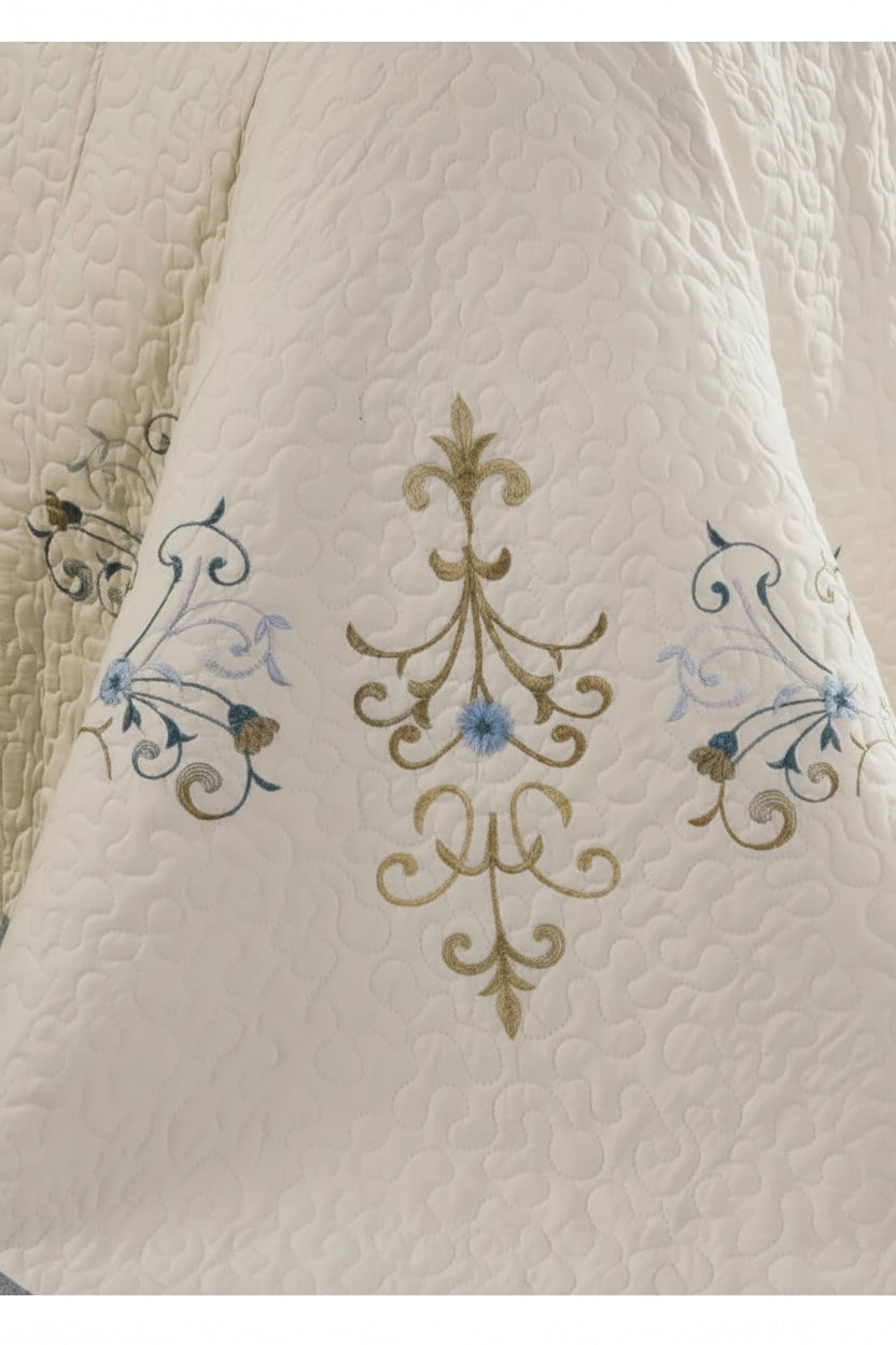 Embroidered fleur-de-lis pattern detail on cotton bed cover drape