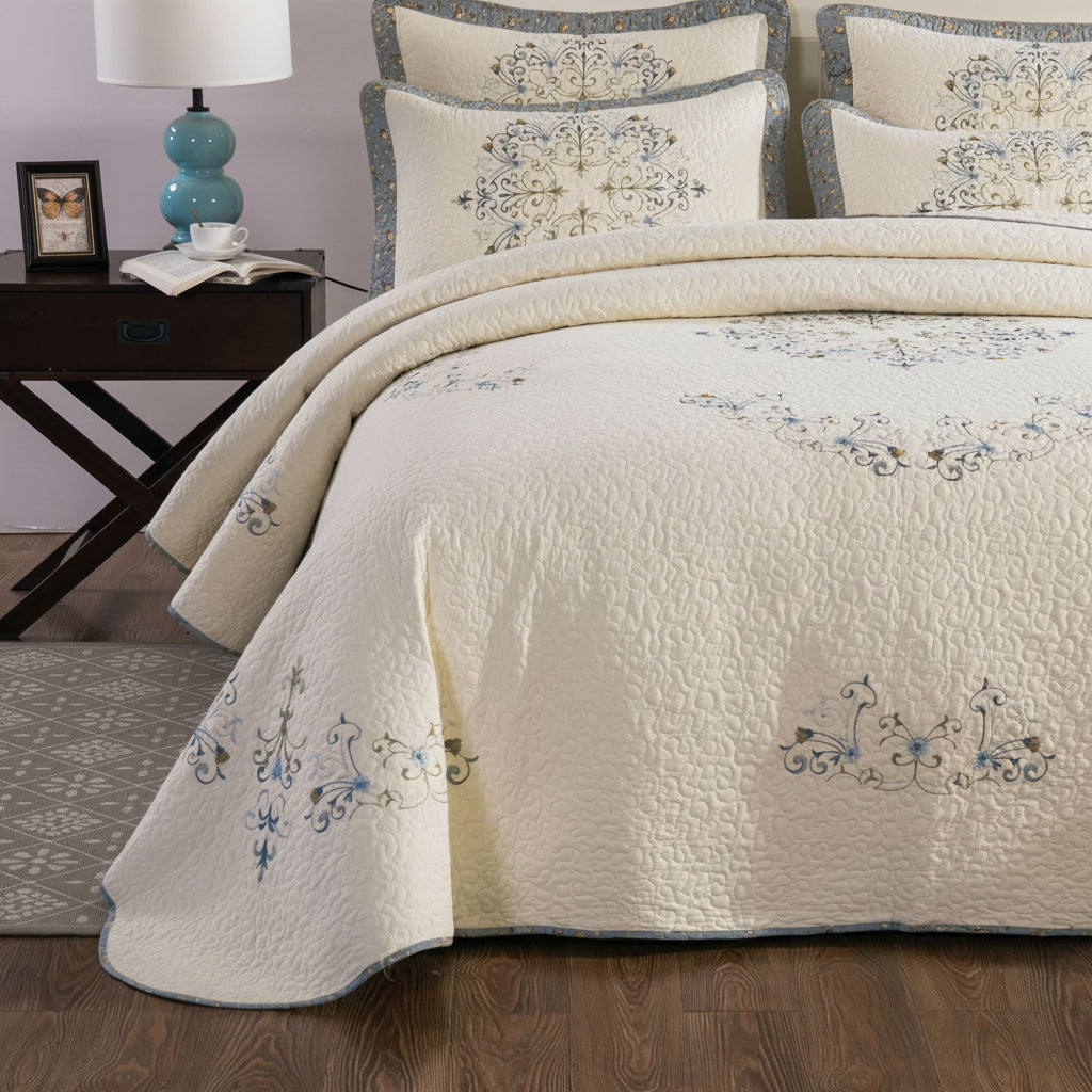 European embroidered pure cotton bed cover draped over bed with matching pillow shams, bedroom styling